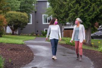 At Home and in the Neighborhood During the COVID-19 Pandemic two women walking in a park in their neighborhood